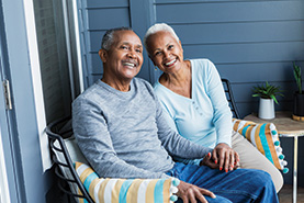 A couple smiling and sitting on a porch. Links to Beneficiary Designations A couple smiling and sitting on a porch. Links to Beneficiary Designations